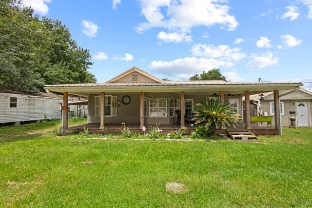 a view of a house with a yard and sitting area