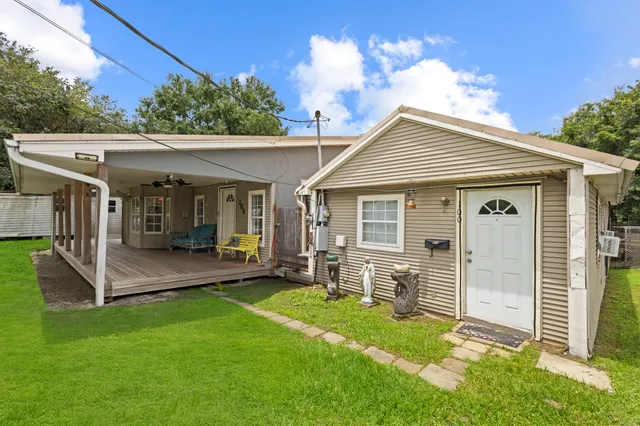 a view of a house with a yard and furniture
