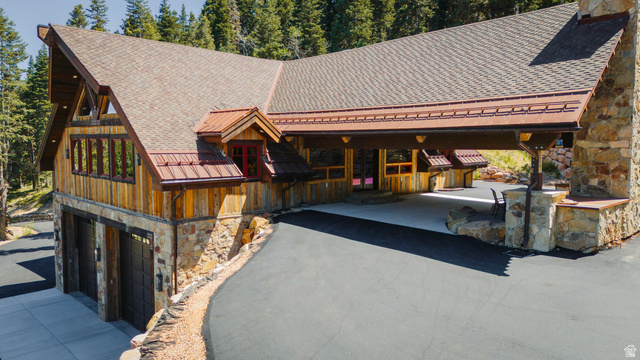 1667 West Tollgate Cyn Road Coalville, UT 84017 - Photo 57 of 61 Rustic-modern exterior featuring natural wood siding, stone veneer accents, and a shingle roof with copper-toned metal details