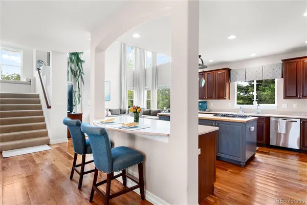 a kitchen with stainless steel appliances granite countertop wooden floor window and dining table