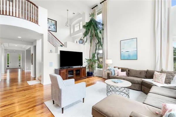 a living room with furniture a flat screen tv and a dining table