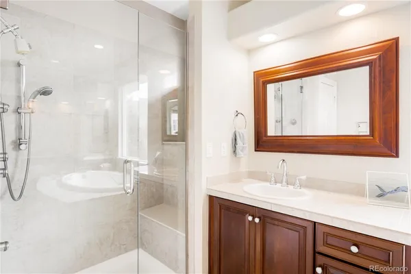 a en suite spacious bathroom with a tub double vanity and window