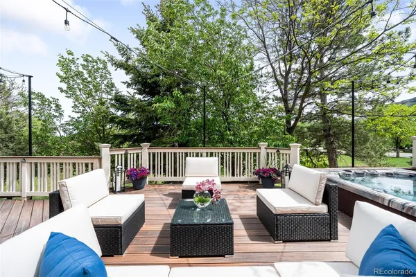 a view of roof deck with couches and wooden fence