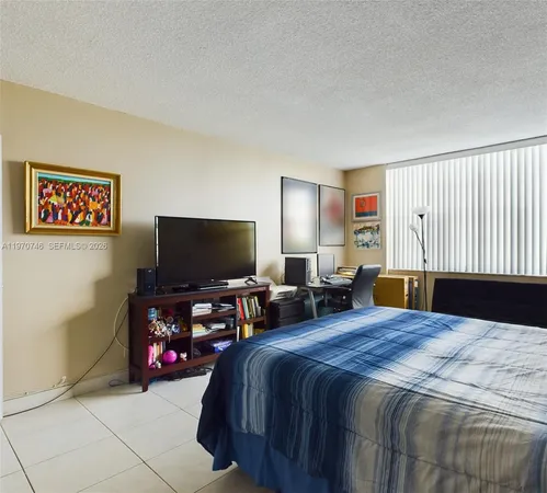 a bedroom with bed and a flat screen tv