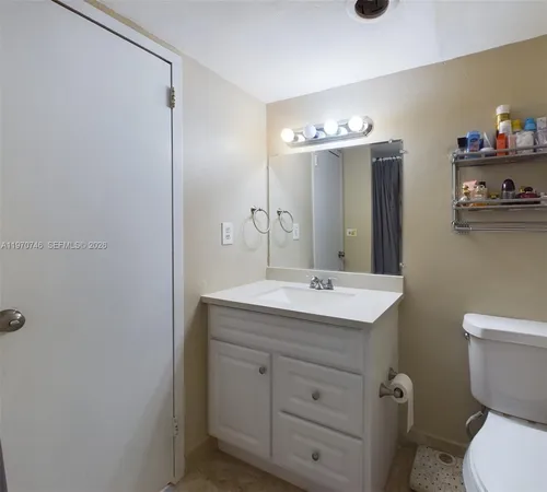 a bathroom with a toilet a sink and mirror