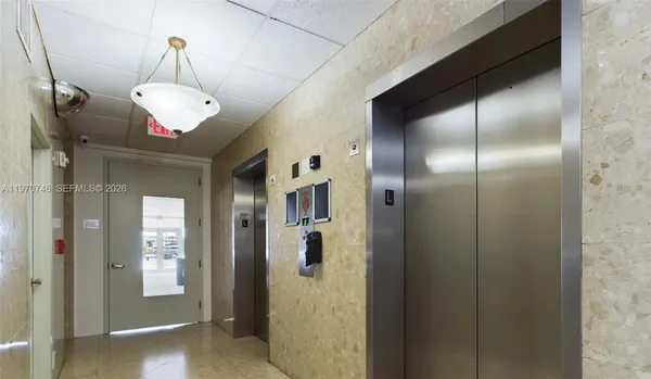 a view of a hallway with wooden floor and chandelier