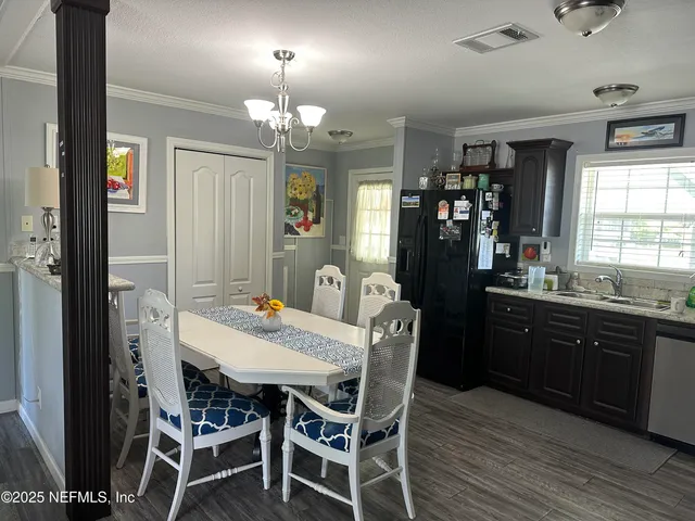 a kitchen with granite countertop a refrigerator cabinets and wooden floor
