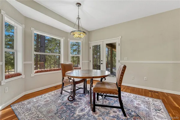 a dining room with furniture a chandelier and wooden floor