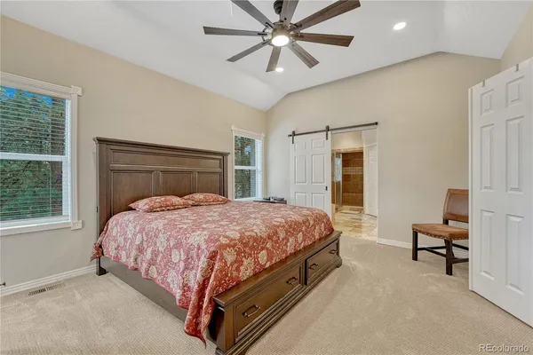 a bed sitting in a spacious bedroom next to a window