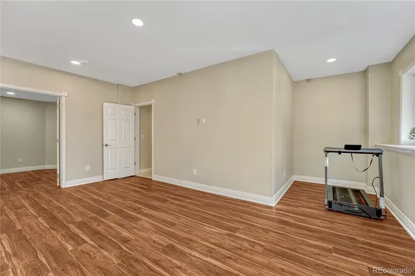 a view of a room with wooden floor and a ceiling fan