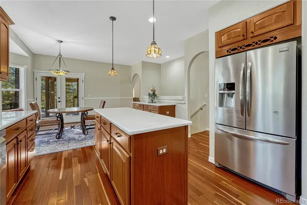 a kitchen with kitchen island a counter top space wooden floor and stainless steel appliances