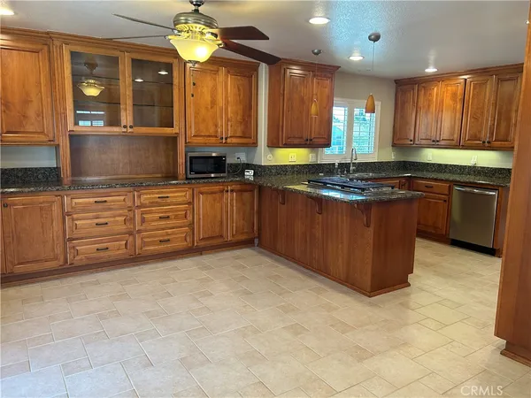 a kitchen with stainless steel appliances granite countertop a stove sink and cabinets