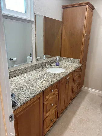 a bathroom with a granite countertop sink and a mirror