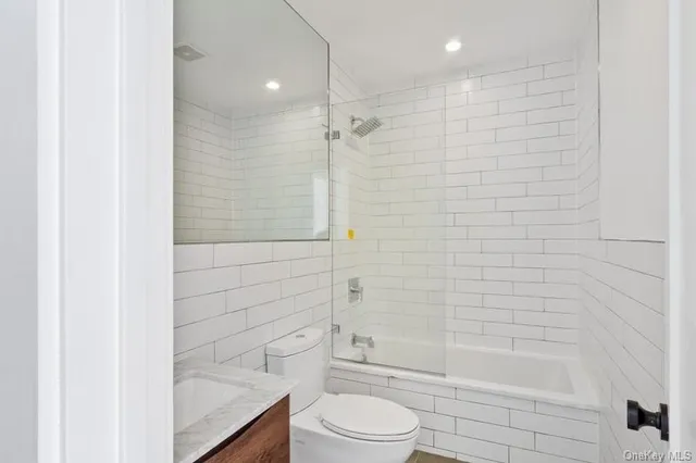 a bathroom with a shower a toilet and bathtub