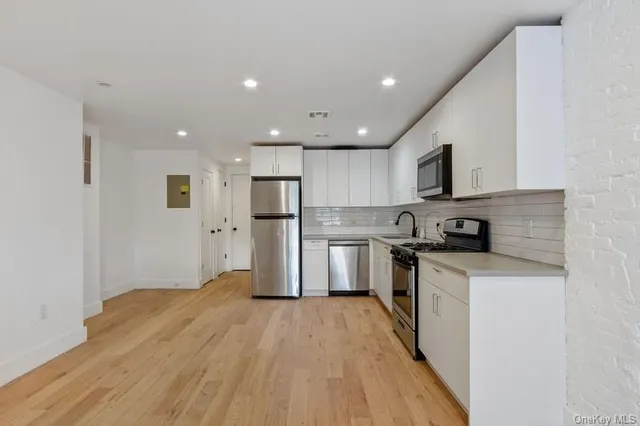 a kitchen with stainless steel appliances granite countertop a refrigerator a stove top oven a sink and dishwasher