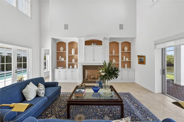 a living room with furniture potted plant and open kitchen view