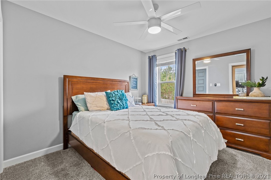 171 Apache Trail Sanford, NC 27332 - Photo 32 of 38 a bedroom with a large bed and a chandelier