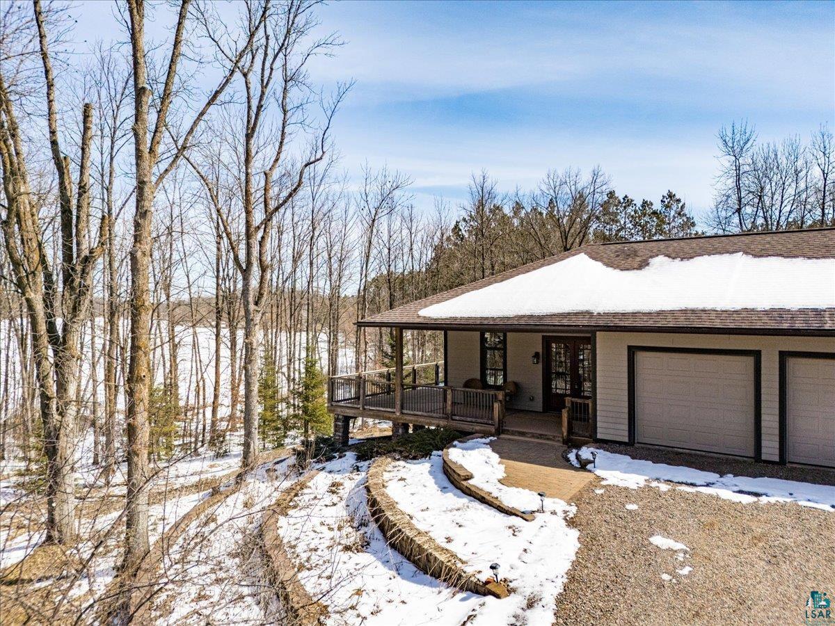 92598 Spells Road Sturgeon Lake, MN 55783 - Photo 58 of 60 View of front facade featuring an attached garage, a porch, and roof with shingles