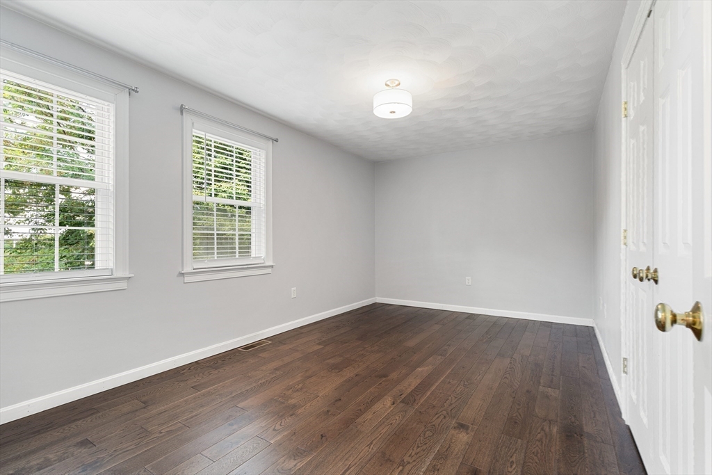2 Ricciuti Drive, Unit 9 Quincy, MA 02169 - Photo 28 of 40 an empty room with wooden floor and windows