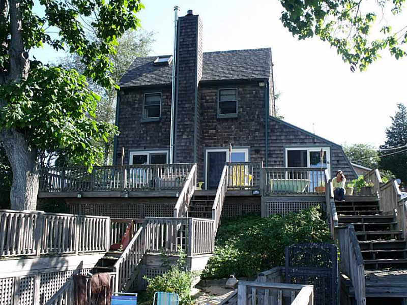 Exterior Back. Multi-level decks, floating dock and private beach.