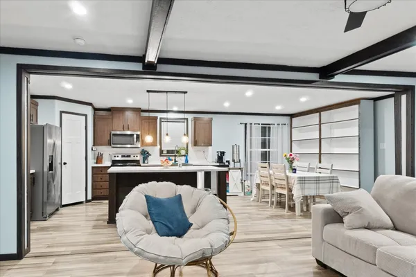 a living room with stainless steel appliances kitchen island granite countertop furniture and a large window