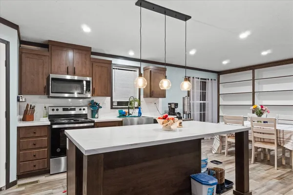 a kitchen with a sink a stove and chairs