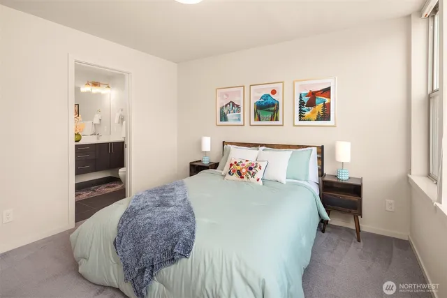 a bedroom with a bed and painting on the wall