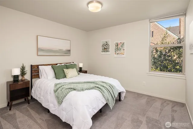 a bed room with a bed and a painting on the wall