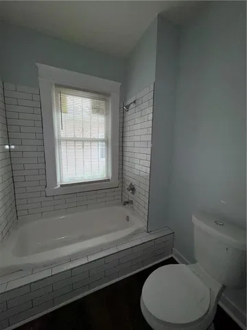 a bathroom with a toilet bathtub and window