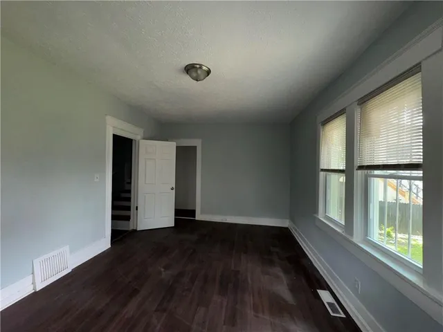 an empty room with wooden floor and a window
