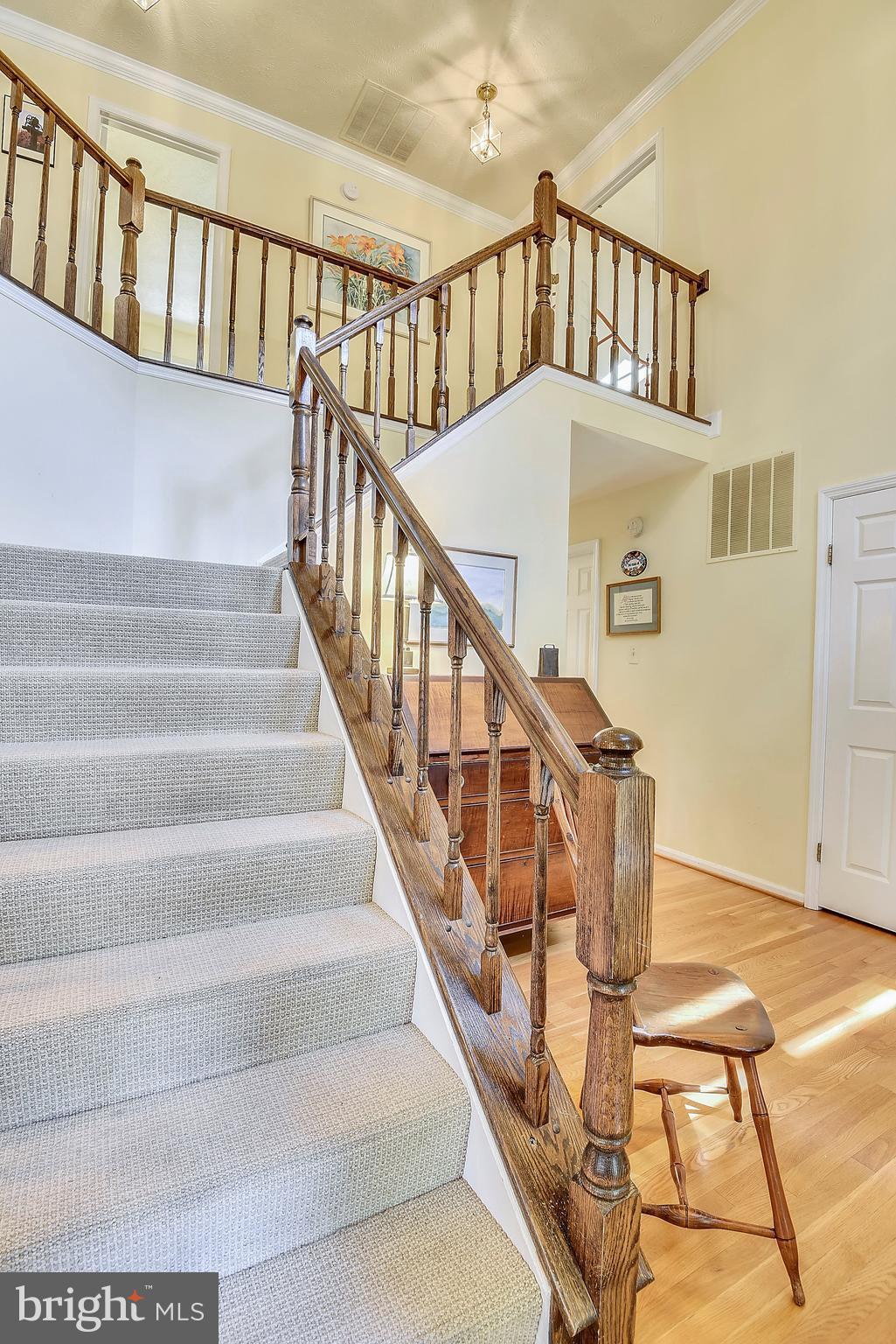 11692 Bennington Woods Road Reston, VA 20194 - Photo 18 of 29 a view of staircase with lots of frames on wall and wooden floor