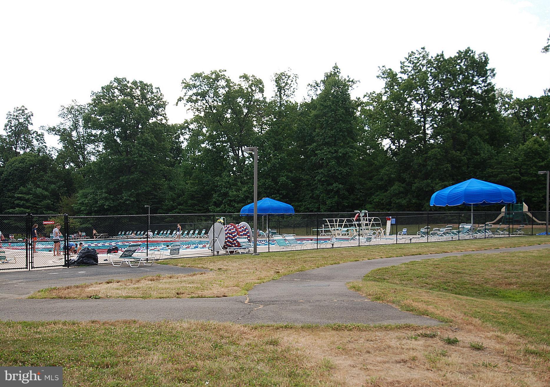 11692 Bennington Woods Road Reston, VA 20194 - Photo 24 of 29 a view of a swimming pool with a lawn chairs under an umbrella