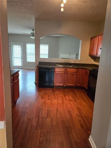 a view of a livingroom with wooden floor and a fireplace