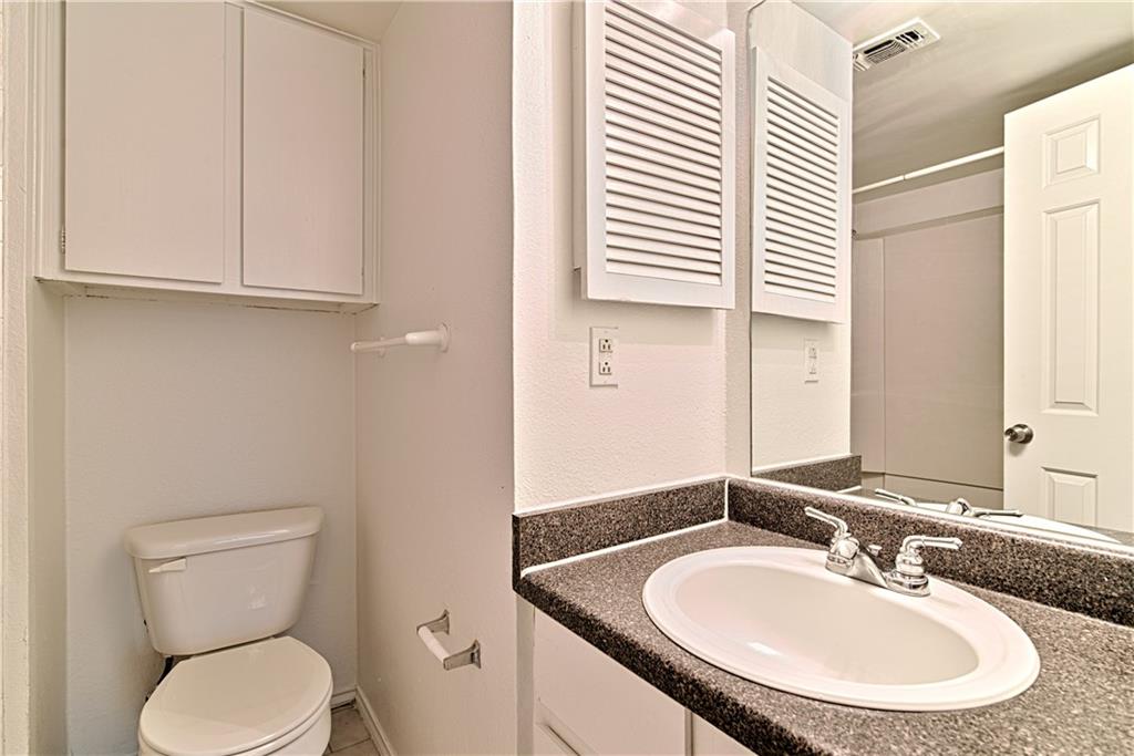 2401 Leon Street, Unit 104 Austin, TX 78705 - Photo 13 of 21 a bathroom with a toilet sink and mirror