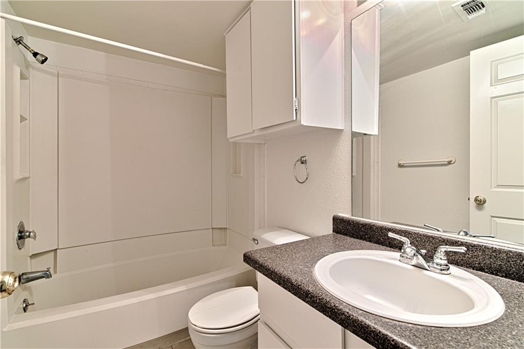2401 Leon Street, Unit 104 Austin, TX 78705 - Photo 14 of 21 a bathroom with a granite countertop sink toilet and shower
