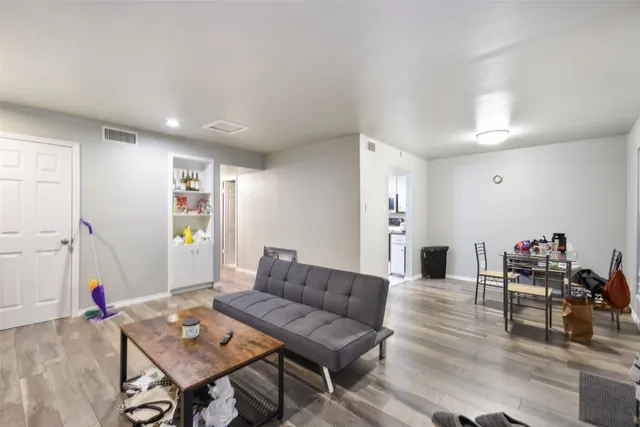 a living room with furniture and wooden floor