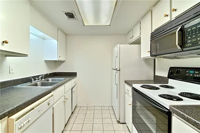 a kitchen with granite countertop a sink stove and refrigerator