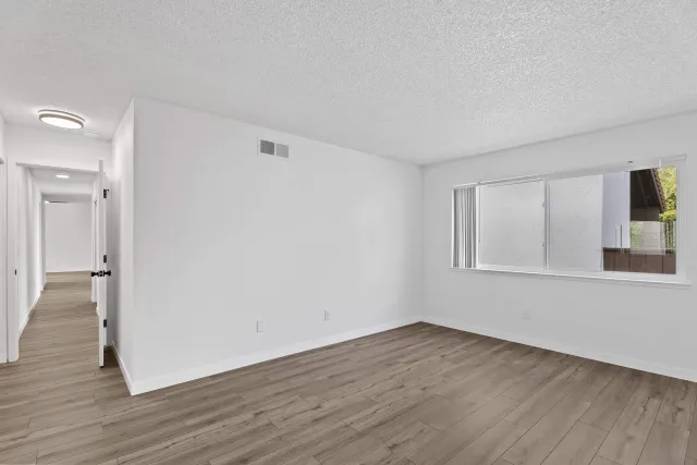 a view of a livingroom with wooden floor and window