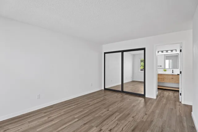 a view of empty room with wooden floor