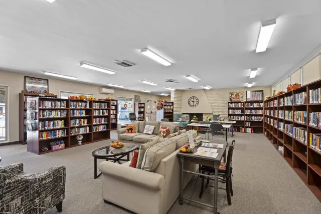 a living room with lots of furniture and a book shelf