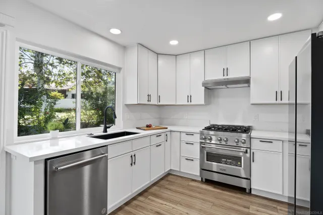 a kitchen with a stove a sink and a window