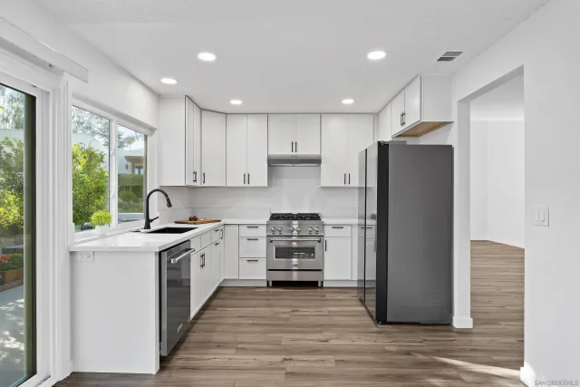 a kitchen with a refrigerator and a stove top oven