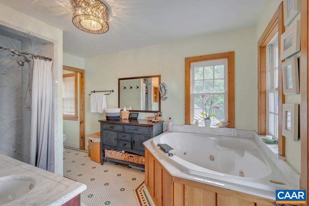 3609 Stony Point Road Charlottesville, VA 22911 - Photo 29 of 58 a bathroom with a tub a sink a mirror and a window