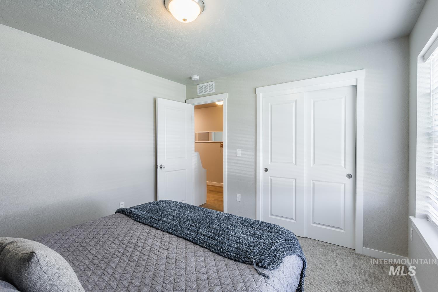 12623 Shadow Peak Street Caldwell, ID 83607 - Photo 36 of 50 Carpeted room with a ceiling-mounted light fixture, white bi-fold closet doors, and a window with blinds