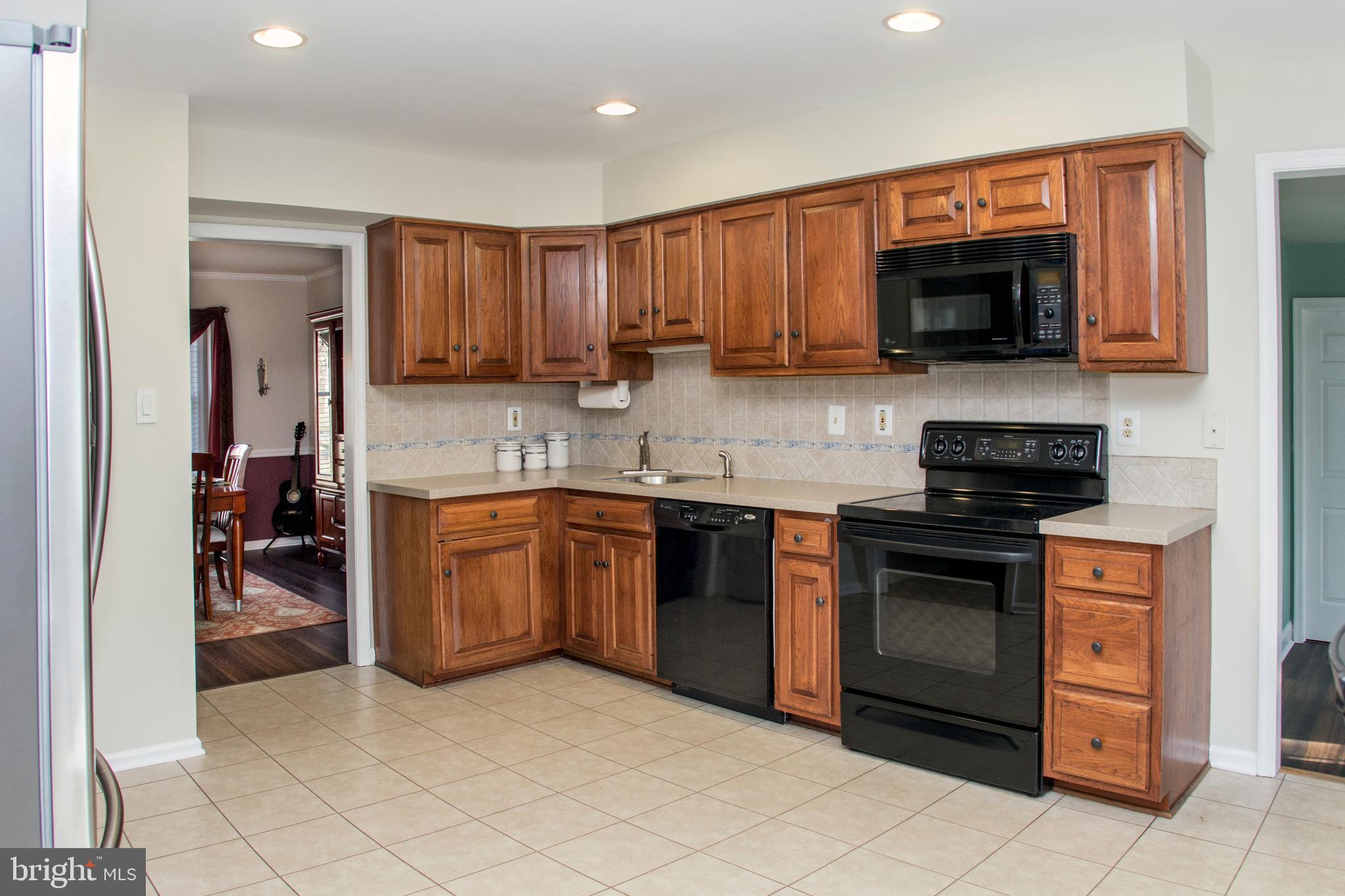 89 Flyatt Road Shamong, NJ 08088 - Photo 5 of 30 a kitchen with stainless steel appliances granite countertop a stove top oven a sink dishwasher and a refrigerator with wooden cabinets