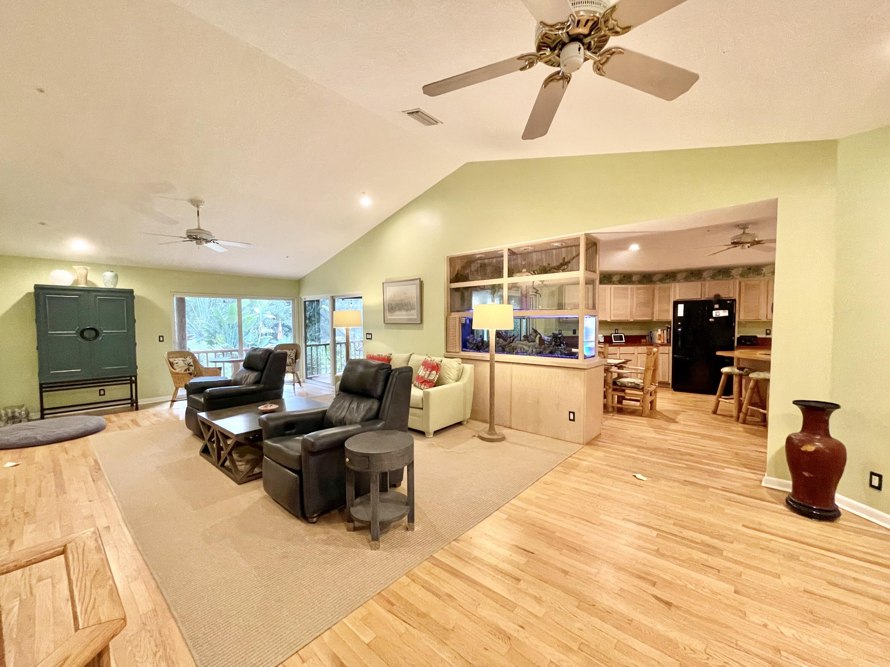 9470 Sandy Run Road Jupiter, FL 33478 - Photo 23 of 48 a living room with furniture kitchen view and a chandelier