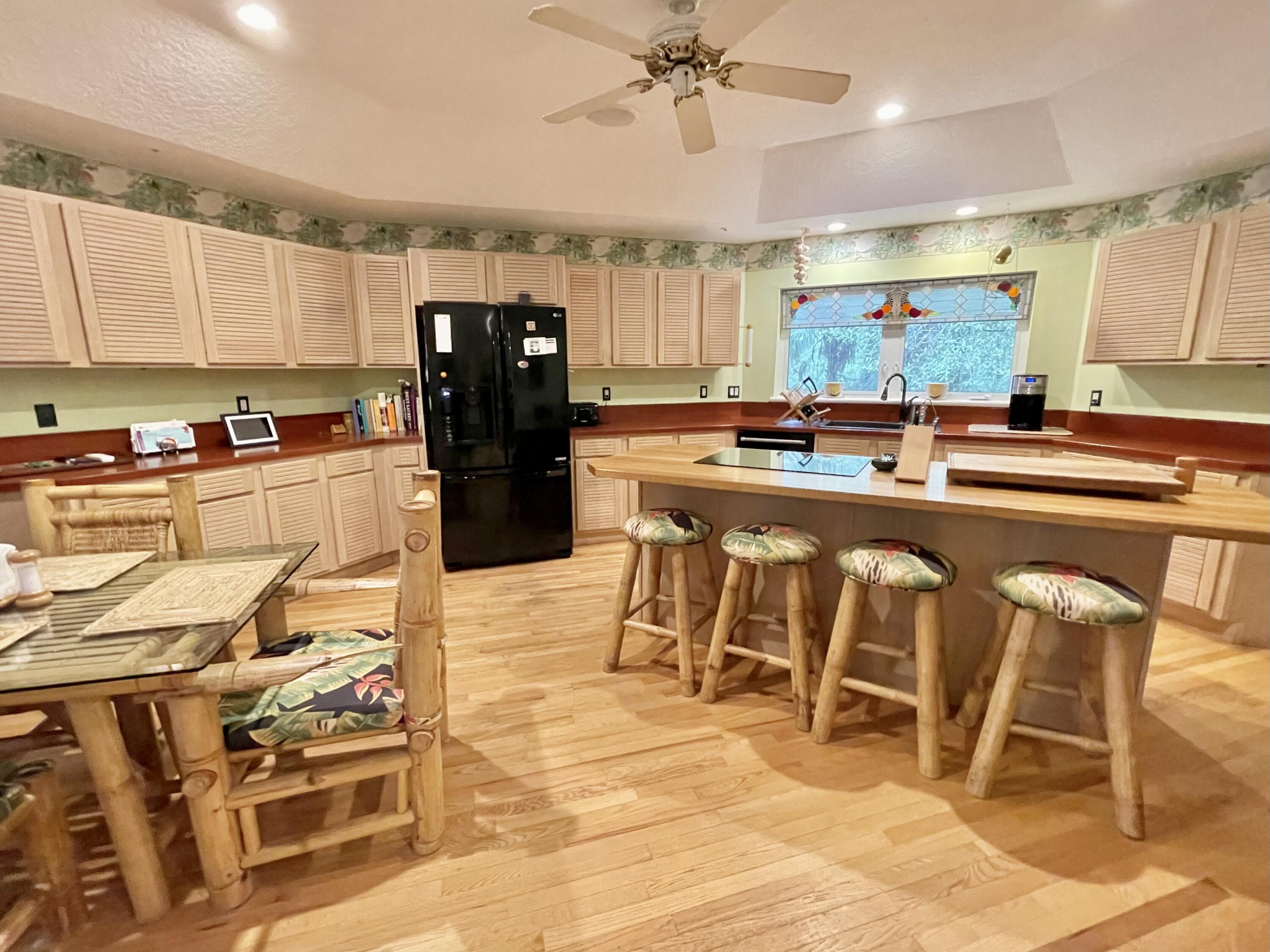 9470 Sandy Run Road Jupiter, FL 33478 - Photo 27 of 48 a kitchen with stainless steel appliances kitchen island granite countertop a table and chairs in it