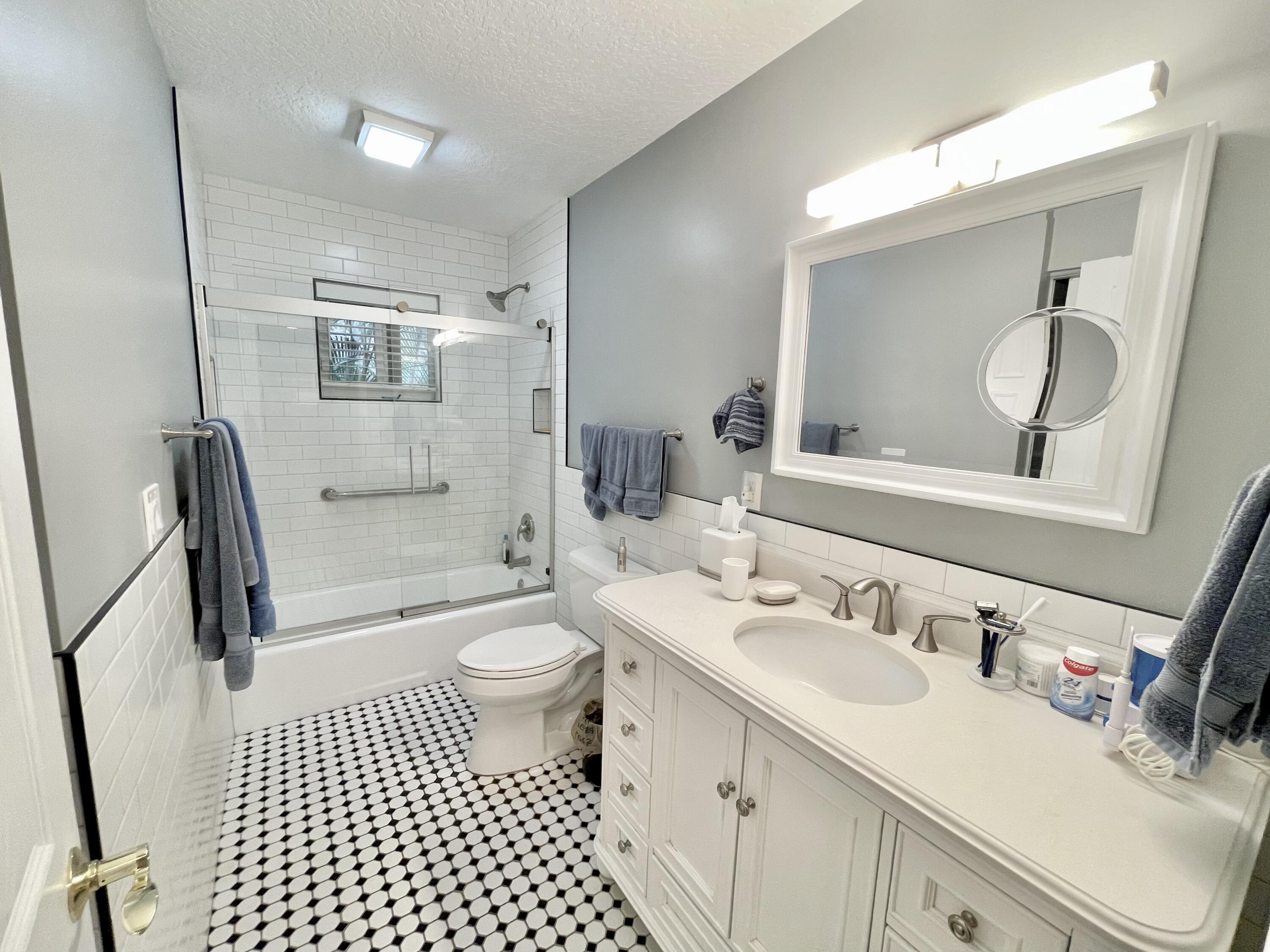 9470 Sandy Run Road Jupiter, FL 33478 - Photo 36 of 48 a bathroom with a sink a toilet a mirror and shower