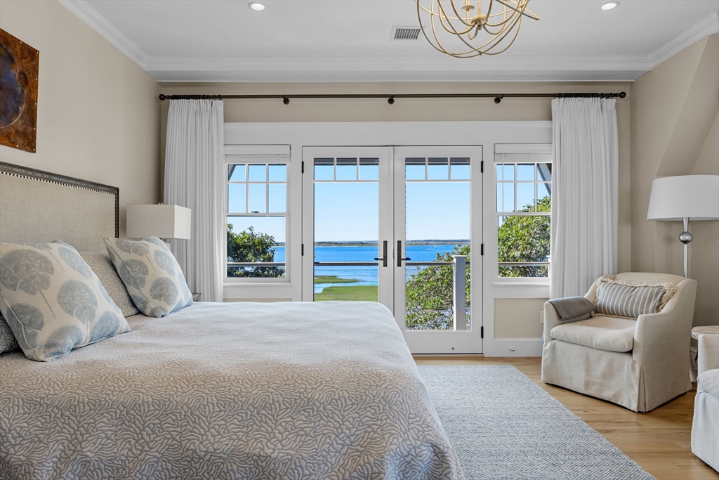 246 Stage Island Road Chatham, MA 02633 - Photo 17 of 37 a spacious bedroom with a bed and glass window