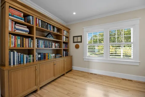 a view of a hallway with wooden floor and staircase